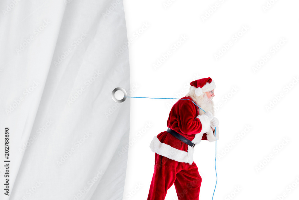Santa claus pulling rope against white curtain blind 