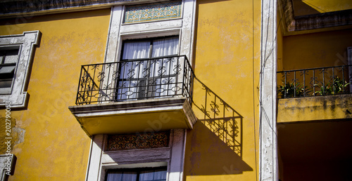Bilde på lerret Colonial hacienda balcony with ornate wrought iron on yellow facade in Mexico, reflecting historic architecture, cultural heritage, and traditional urban design