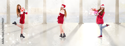 Festive redhead holding a gift against twinkling lights over balcony with columns