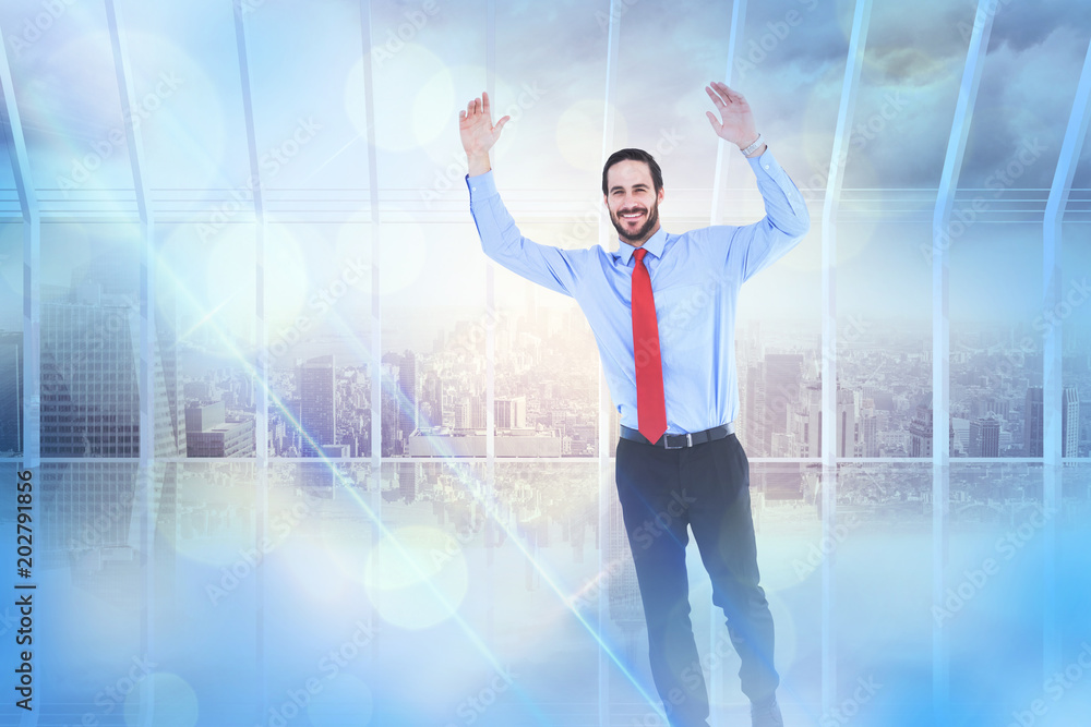 Smiling businessman stepping with hands raised against room with large window looking on city Smiling businessman stepping with hands raised against room with large window looking on city