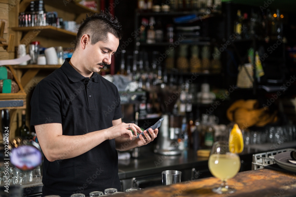 Male barista using phone