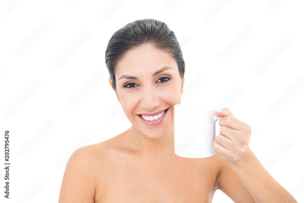 Attractive brunette holding a white mug and smiling at camera Attractive brunette holding a white mug and smiling at camera