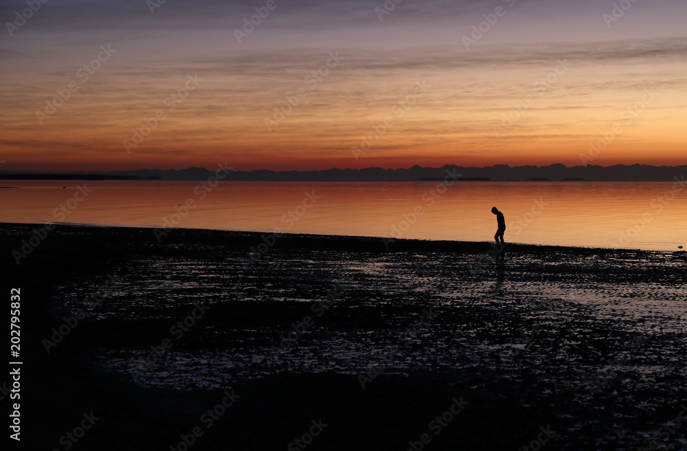 A man walking against the stunning sunrise on the East Cape of Everglades National Park, Florida..