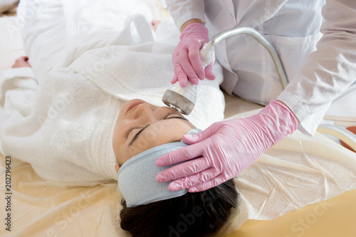 High angle portrait of pretty brunette woman enjoying beauty treatment in cosmetologist office, copy space