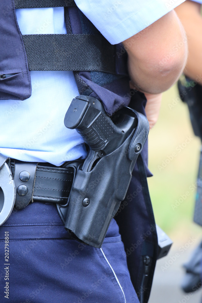 Polizei-Pistole im Halfter eines Polizisten Photos | Adobe Stock