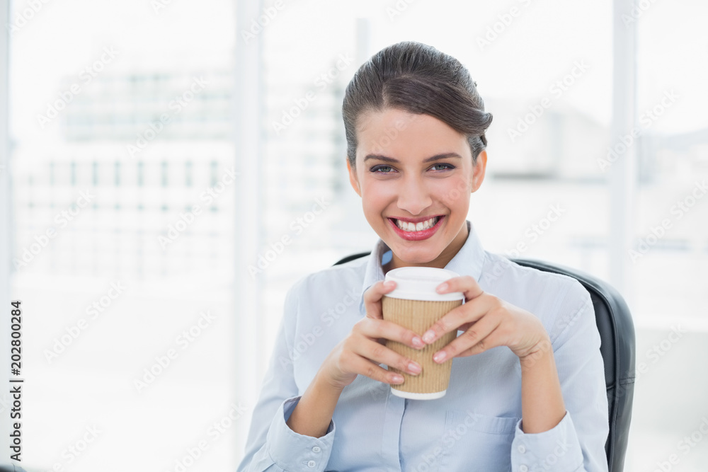 Delighted classy brown haired businesswoman enjoying coffee Delighted classy brown haired businesswoman enjoying coffee