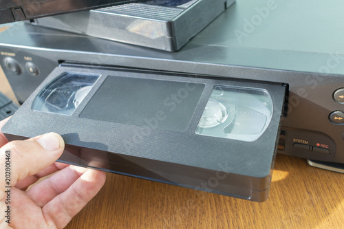 insert a videotape into a tape recorder