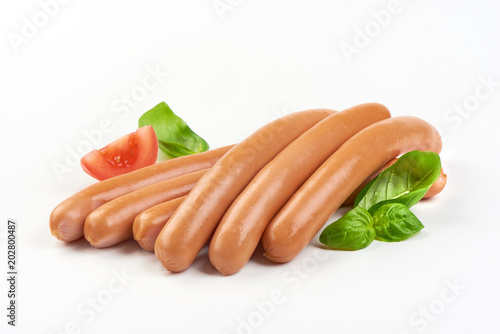 frankfurter sausages with green herbs and vegetables isolated on the white background.