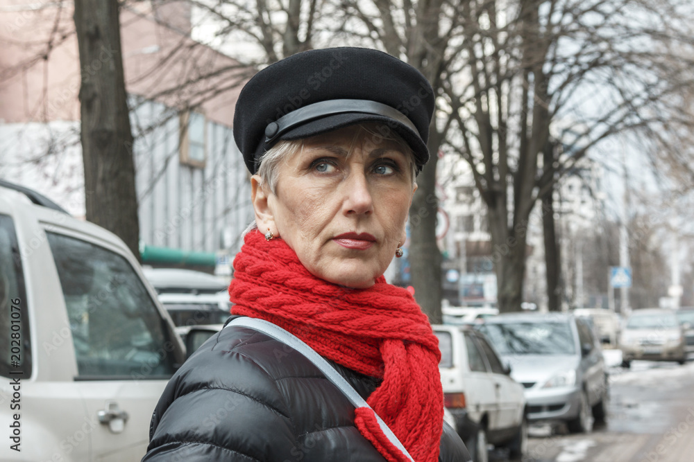 serious middle-aged woman with wrinkles on face and red scarf. closeup portrait of elegant middle aged woman with gray hair. serious middle-aged woman with wrinkles on face and red scarf. closeup portrait of elegant middle aged woman with gray hair.