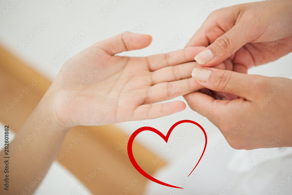 Woman receiving a hand massage against heart Woman receiving a hand massage against heart