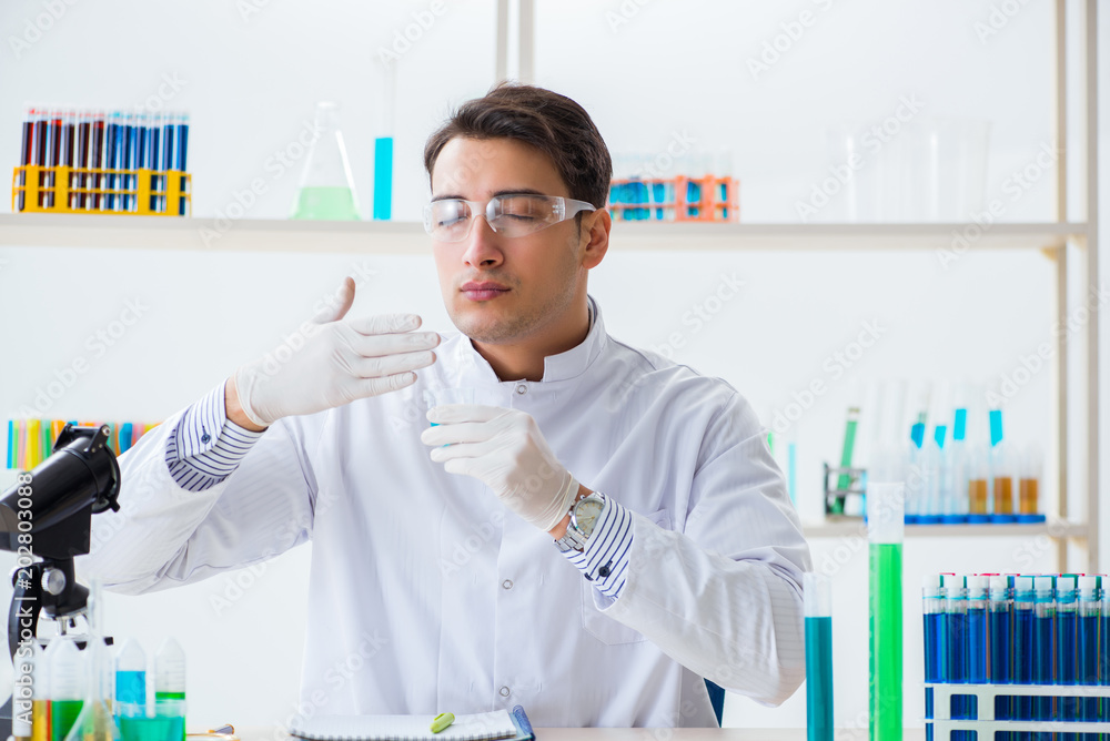 Young chemist student working in lab on chemicals Young chemist student working in lab on chemicals