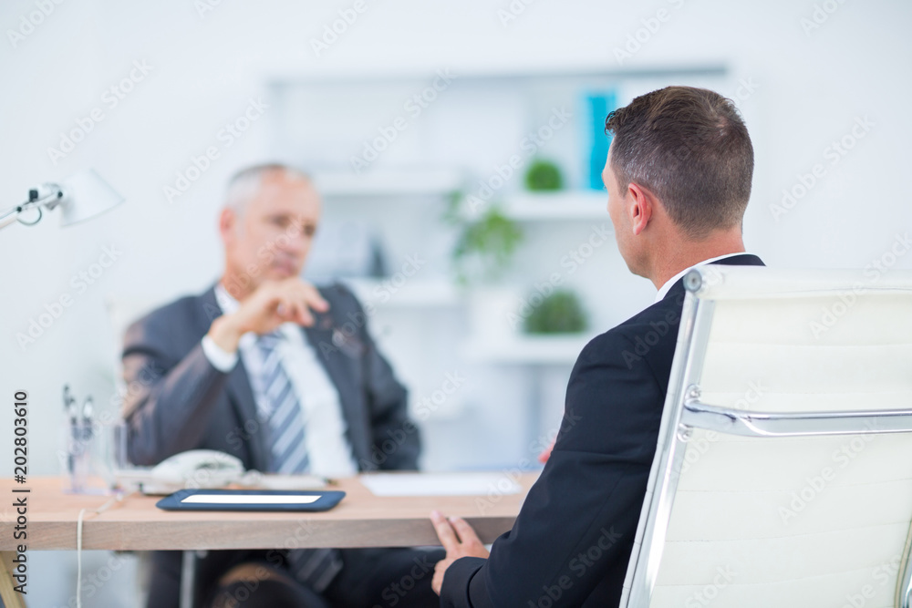 Two businessmen sitting and speaking Two businessmen sitting and speaking