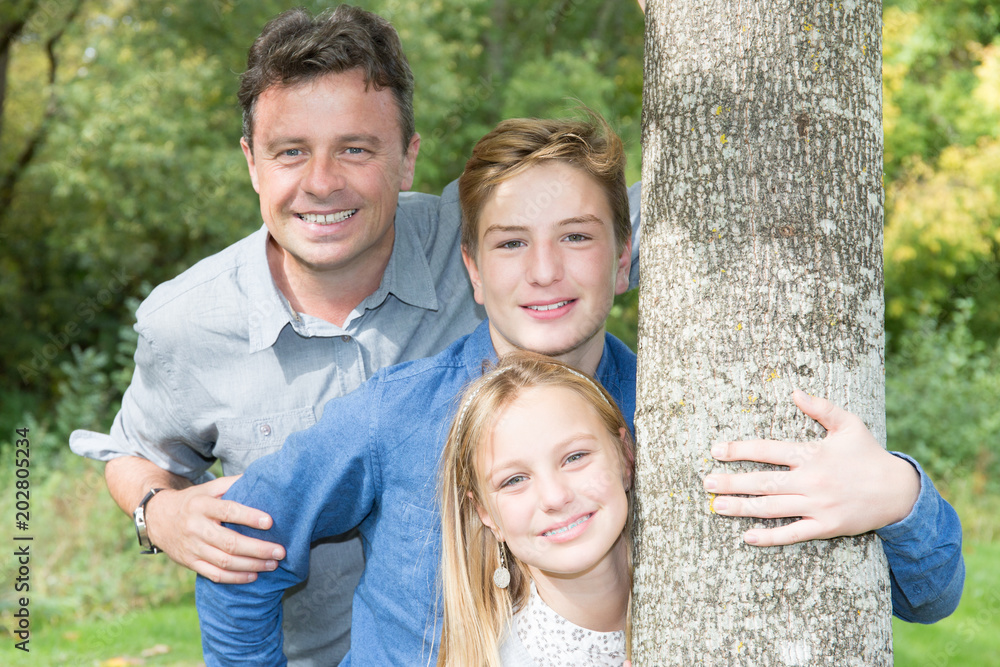 Happy father daughter and son have a fun in public park