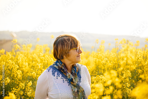 Senior woman in a field of yellow flowers