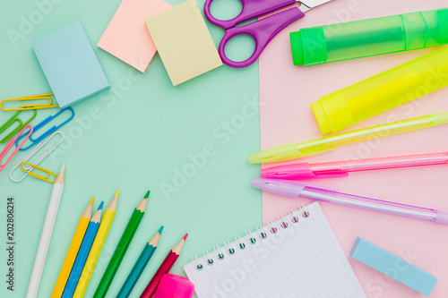 Flat lay lots of stationery on mint pink background, pens, stickers, Notepad, paper clips, markers, erasers, scissors. The concept of preparing children back to school. Copy space.