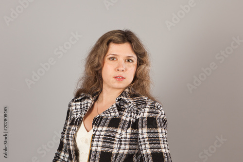 Fashion photo of a young woman with curly hair wearing white dress and jacket © satura_