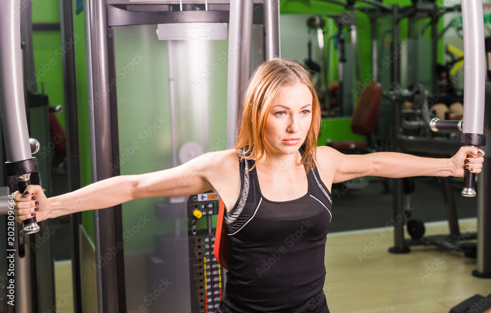Athletic young woman works out on simulator in gym class Athletic young woman works out on simulator in gym class