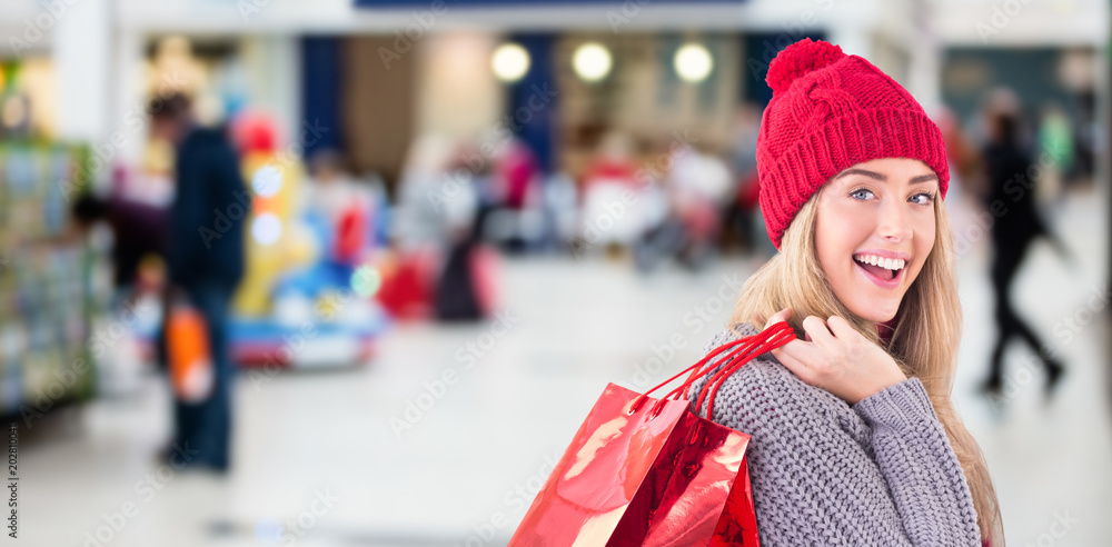Festive blonde holding shopping bags against shopping mal Festive blonde holding shopping bags against shopping mal