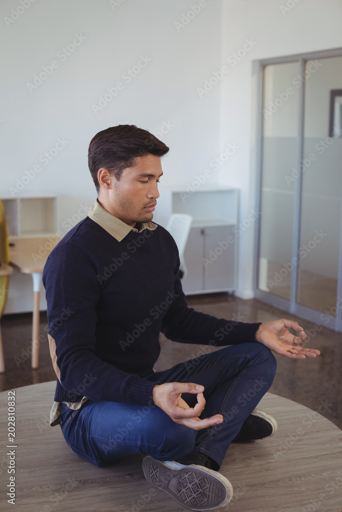 Young businessman practicing yoga at office Young businessman practicing yoga at office