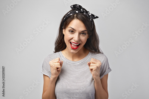Winning, victory, success, good luck and achievement concept. Picture of emotional ecstatic lucky young Caucasian female winner expressing excitement and delight, shouting Yes, clenching fists
