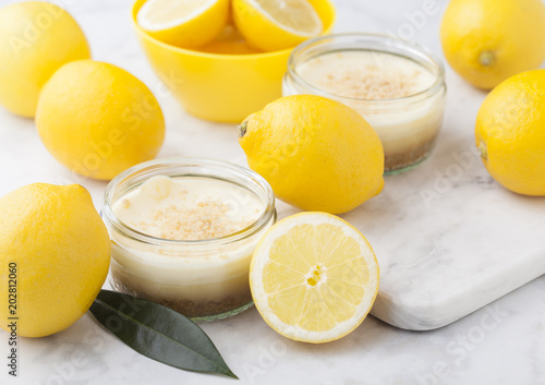 Glass jar with lemon cheesecake with fresh lemons photo