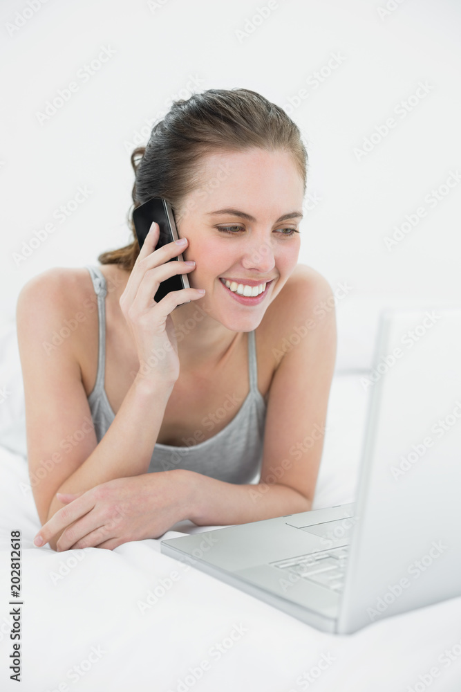 Smiling casual woman using cellphone and laptop Smiling casual woman using cellphone and laptop