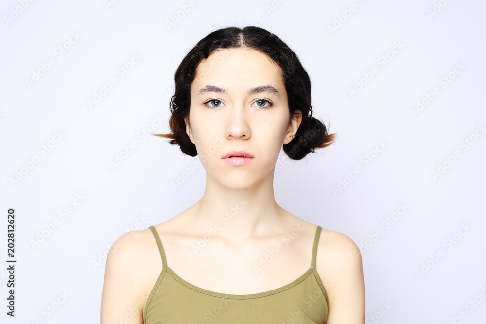 Fototapeta premium Young cheerful girl looking at camera over white background.