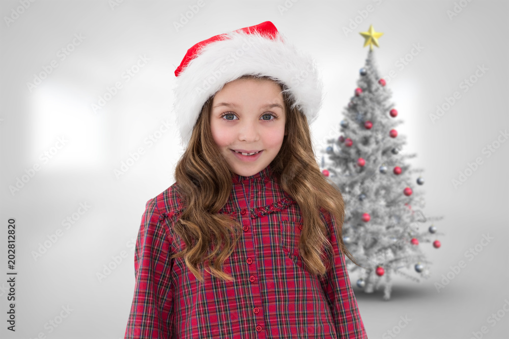 Cute girl in santa hat against christmas tree in bright room Cute girl in santa hat against christmas tree in bright room