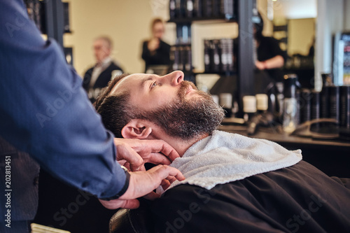 Master hairdresser prepares the face for shaving in the barber shop.