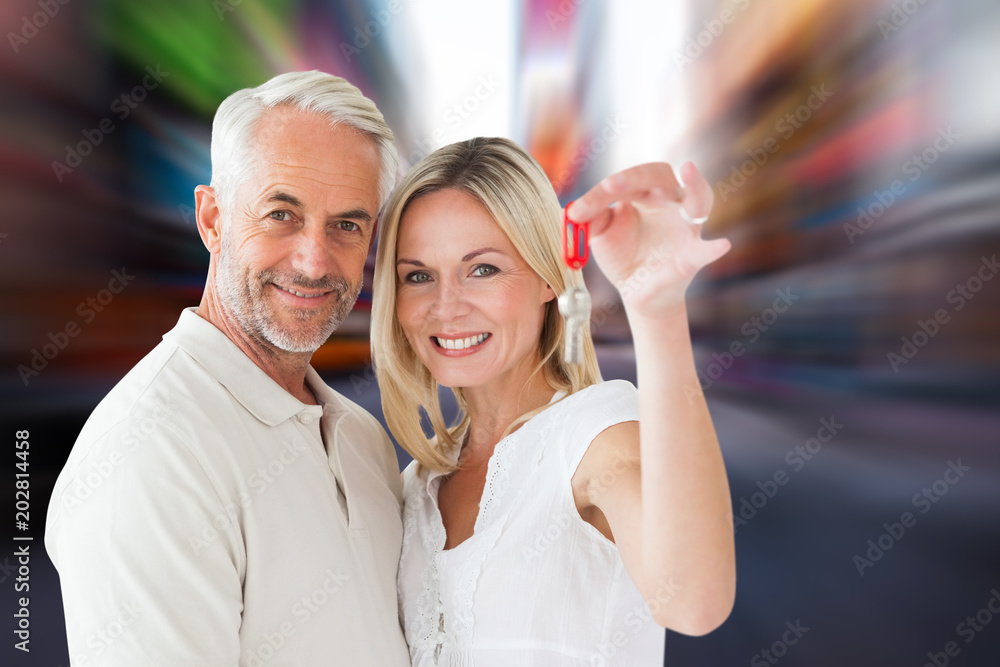 Happy couple showing their new house key against blurry new york street Happy couple showing their new house key against blurry new york street