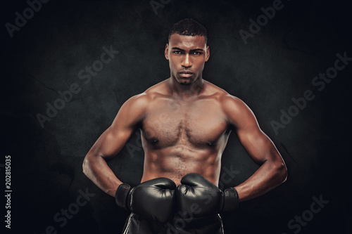 Muscular boxer against dark background