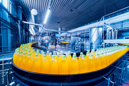 Beverage factory interior. Conveyor with bottles for juice or water. Equipments photo