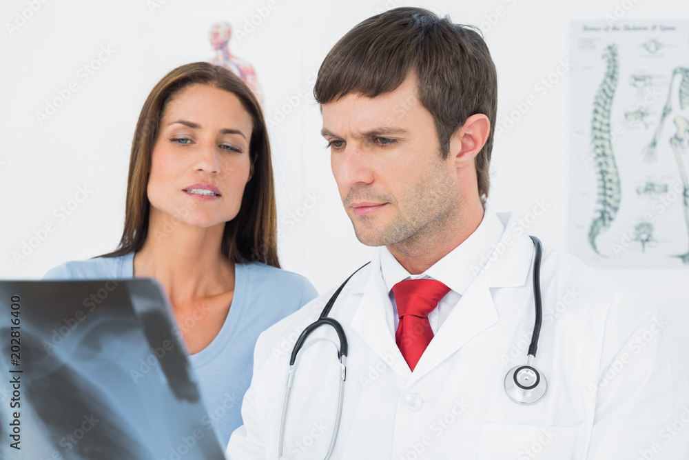 Male doctor explaining lungs xray to female patient Male doctor explaining lungs xray to female patient