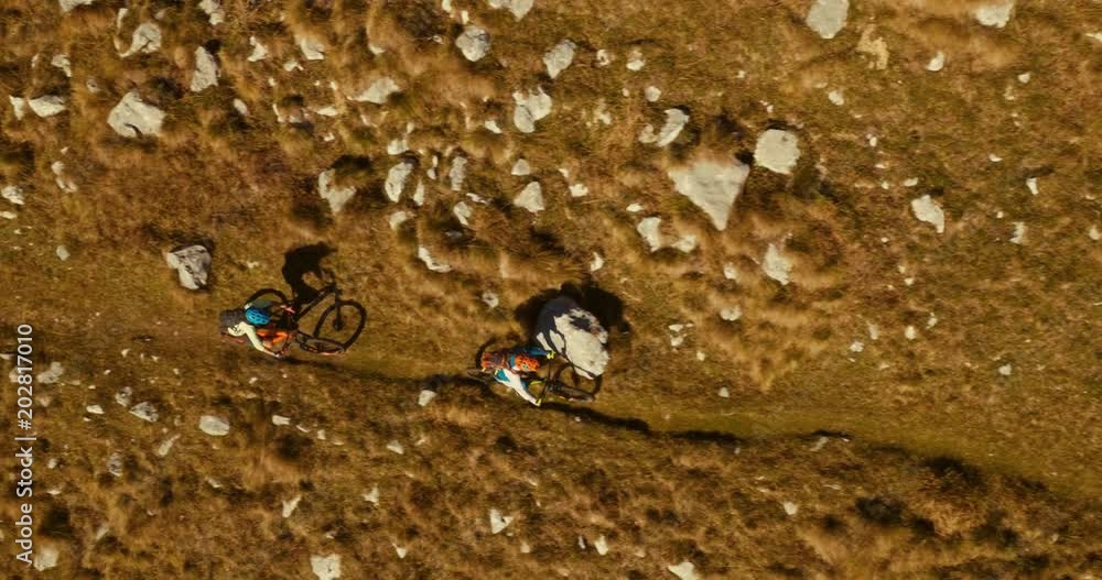 Vertical close-up of two mountain bikers riding a singletrack to the top - left to right. Vertical close-up of two mountain bikers riding a singletrack to the top - left to right.