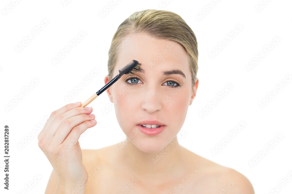 Attractive blonde using eyebrow brush