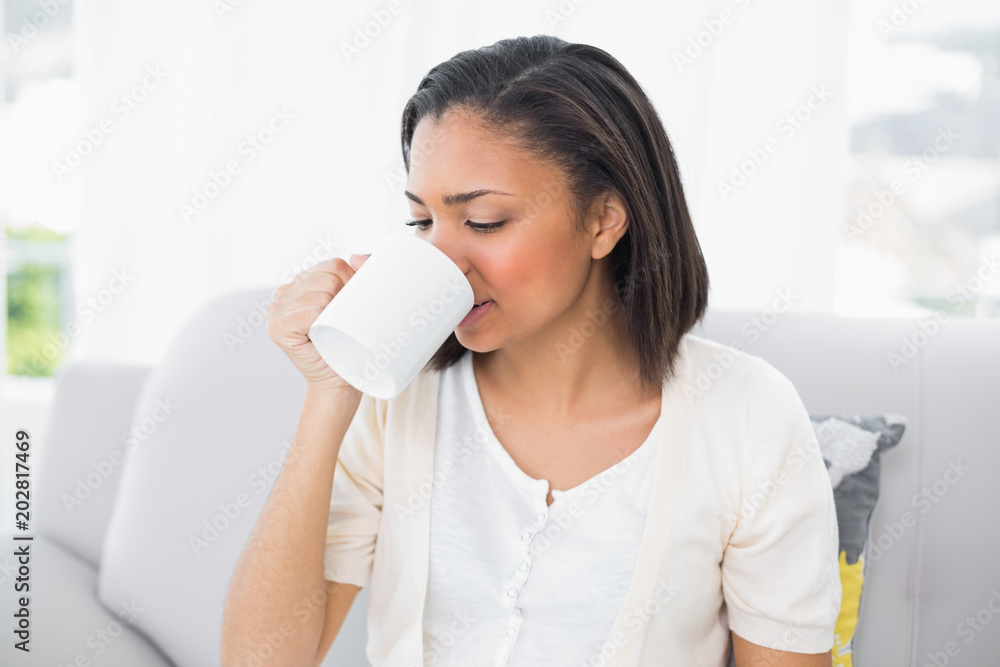 Attractive young dark haired woman in white clothes drinking coffee Attractive young dark haired woman in white clothes drinking coffee