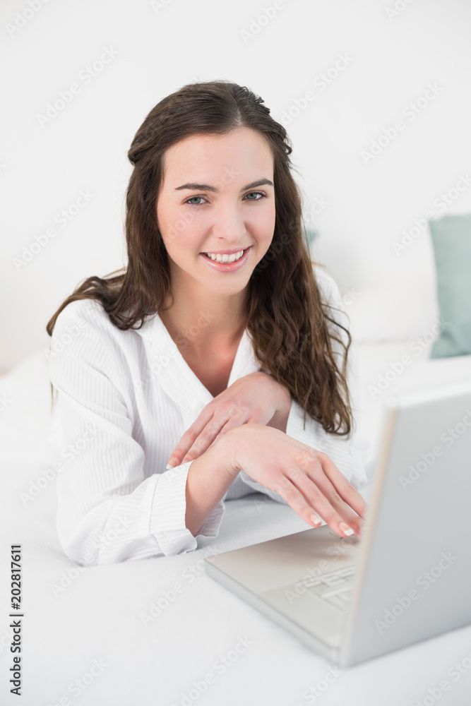 Relaxed casual brunette using laptop in bed Relaxed casual brunette using laptop in bed