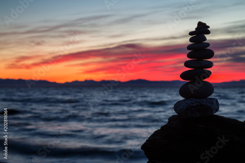 Stack of Rocks piled up by the ocean during a colorful sunset. Taken in Wreck Beach  Vancouver  British Columbia  Canada.