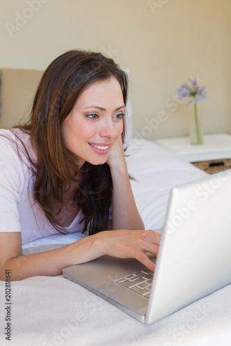 Relaxed woman using laptop in bed