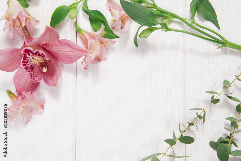 Frame with flowers on white wooden background. Concept Frame with flowers on white wooden background. Concept