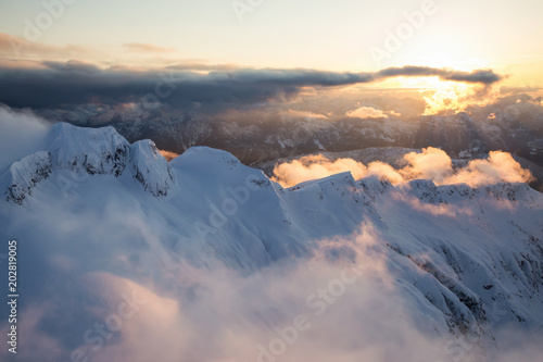 Striking aerial landscape view of the beautiful Canadian Mountains during a dramatic sunset. Taken North of Vancouver, British Columbia, Canada.