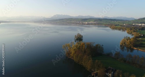 Aerial view on a spring morning from the lake shore of lake Sempach near the city of Sursee with Mount Pilatus in background in central Switzerland