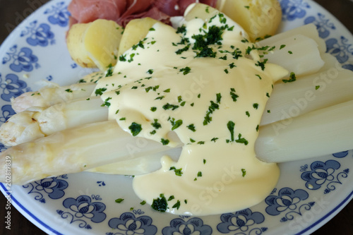 Fresh asparagus with ham and potatoes served on a plate 
