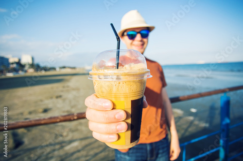 Man's hands close up holding frappe coffee cup photo