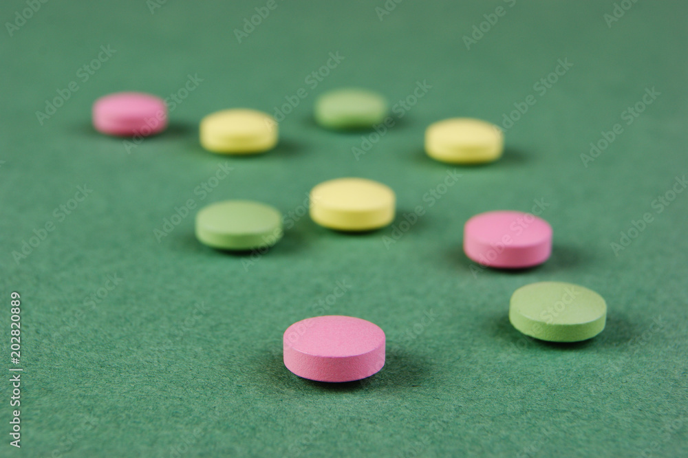 Pills and tablets on a green background Pills and tablets on a green background