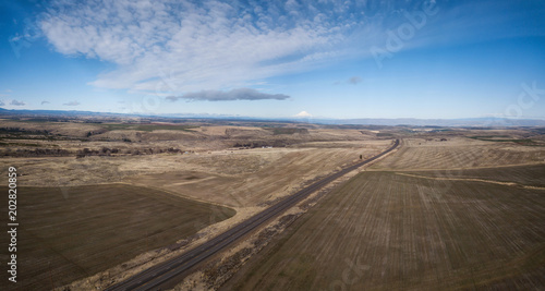 Aerial panorama of a highway passing through a desert area. Taken in Oregon, North America.