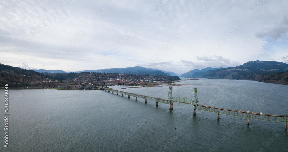 Naklejka premium Aerial panorama of a bridge going over Columbian River between Oregon and Washington during a winter day.