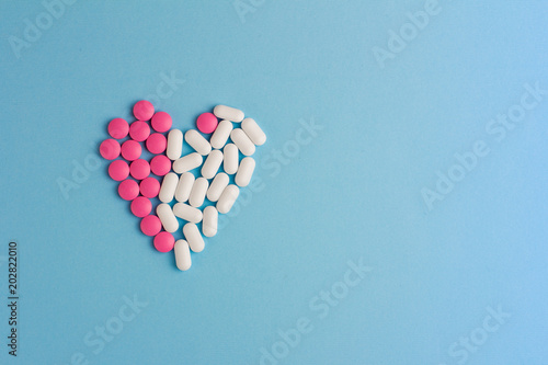 Heart of pills on a blue background. Left view. Copy space for text, logo and design