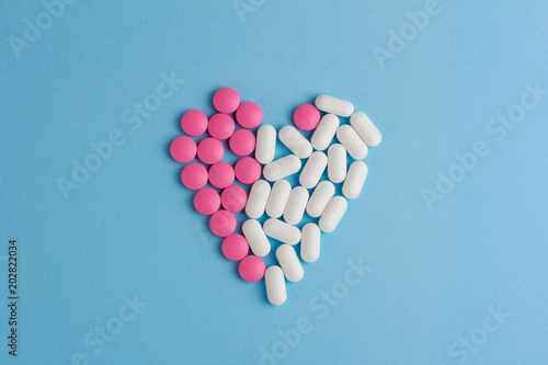 Heart of pills on a blue background. Close-up