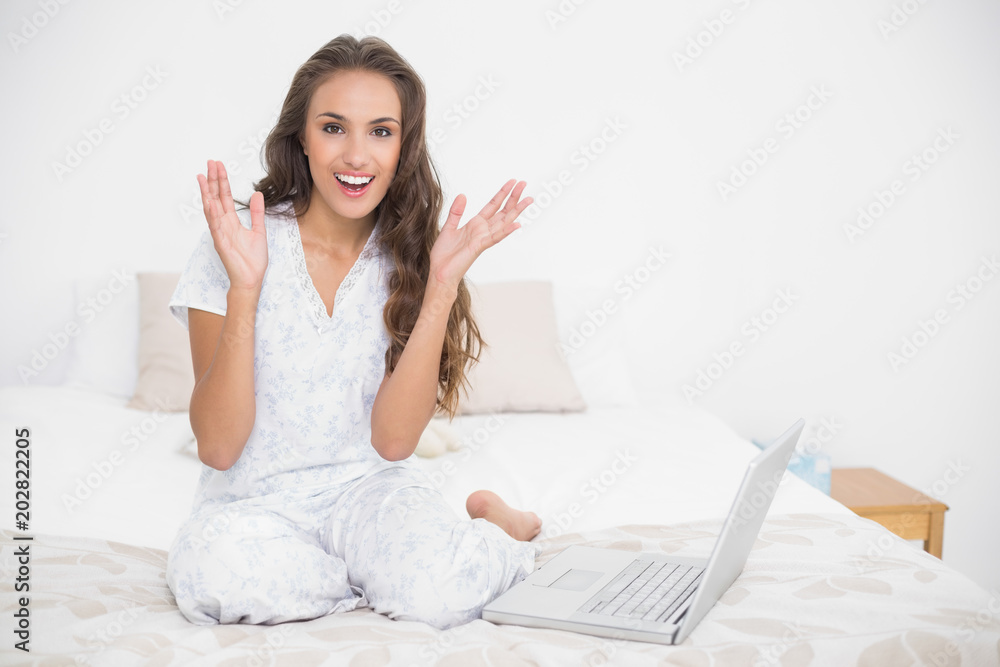 Surprised attractive brunette sitting next to a laptop Surprised attractive brunette sitting next to a laptop